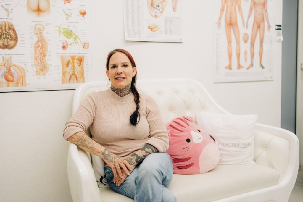 Gaby sitzt auf dem weissen Sofa im Studio