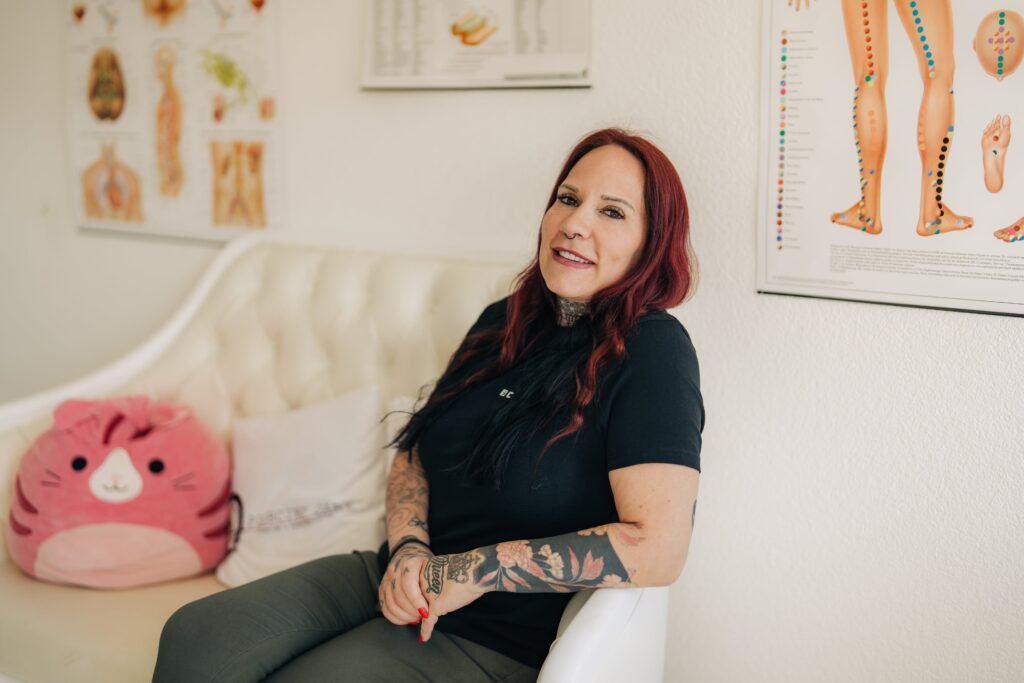 Gaby sitzt im Studio neben der Behandlungsliege