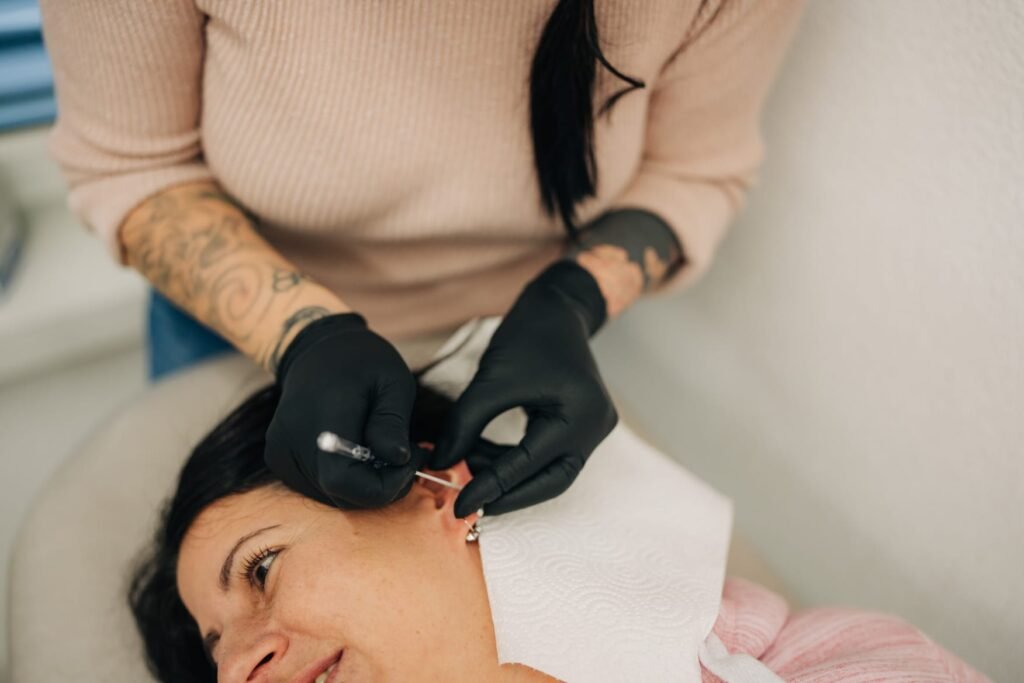 Gaby beim Setzen eines Ohrpiercings